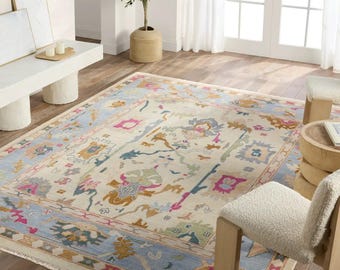 Alfombra Oushak anudada a mano: alfombra vintage turca de lana con borde azul floral pastel.