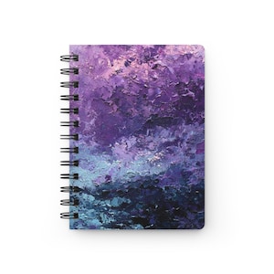 Op de afbeelding: Spiraalgebonden notitieboek met een omslag met een abstract schilderij in tinten paars, blauw en zwart. Het kunstwerk heeft een textuur, impasto-stijl, waardoor een gevoel van diepte en beweging ontstaat. De spiraalbinding van het notitieboek is zwart.