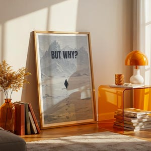 Könnte beinhalten: Ein gerahmter Kunstdruck mit dem Text „BUT WHY?“ zeigt einen Pinguin, der durch eine verschneite Landschaft geht. Das Kunstwerk wird neben einer Vase mit getrockneten Pflanzen, Büchern und einem orangefarbenen Beistelltisch mit Lampe und Büchern ausgestellt.