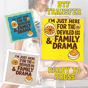 May include: DTF transfer designs with the text "I'M JUST HERE FOR THE DEVILED EGS & FAMILY DRAMA" in a playful font. The designs feature a deviled egg graphic. The words "READY TO PRESS" are also visible.