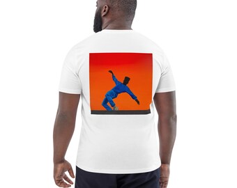 May include: White t-shirt with a square graphic on the back featuring a person in a blue outfit against an orange and red background. The person is in a dynamic pose. The shirt is made of a soft material.