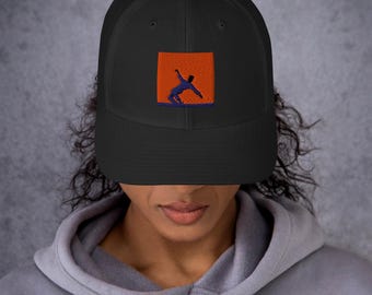 May include: Black trucker hat with a mesh back and a curved brim. The front features a square orange patch with a blue silhouette of a person in motion. The hat is worn by a person wearing a gray hoodie.