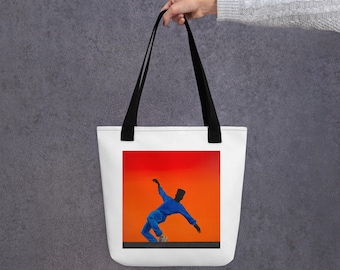May include: White tote bag with black handles. The bag features a vibrant image of a person in a blue outfit against a red and orange background. The person is in a dynamic pose, suggesting movement.