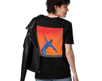 May include: A black t-shirt featuring a square graphic on the back. The graphic displays a person in a blue outfit leaning to the side against a vibrant orange and red gradient background. A black leather jacket is draped over the shoulder.