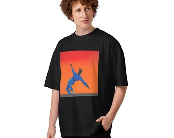 May include: A black oversized t-shirt featuring a square graphic print on the chest. The graphic depicts a person in a blue outfit leaning to the side against a vibrant orange and red gradient background, set above a solid gray horizontal bar.