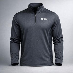 May include: Dark grey long-sleeved pullover with a quarter-zip collar. The word "TEAM" is printed in white on the chest. This athletic top is designed for comfort and performance.