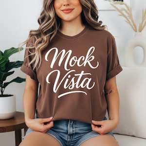 Comfort Colors 1717 T-shirt mockup bundle featuring 30 different shirt colors displayed on a model in boho-style indoor settings. Each tee shows a ‘Mock Vista’ design placeholder, arranged in a grid layout for POD and apparel mockup use.