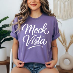 Comfort Colors 1717 T-shirt mockup bundle featuring 30 different shirt colors displayed on a model in boho-style indoor settings. Each tee shows a ‘Mock Vista’ design placeholder, arranged in a grid layout for POD and apparel mockup use.