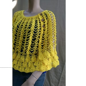 May include: A yellow crocheted poncho with a scalloped hem and button closures.