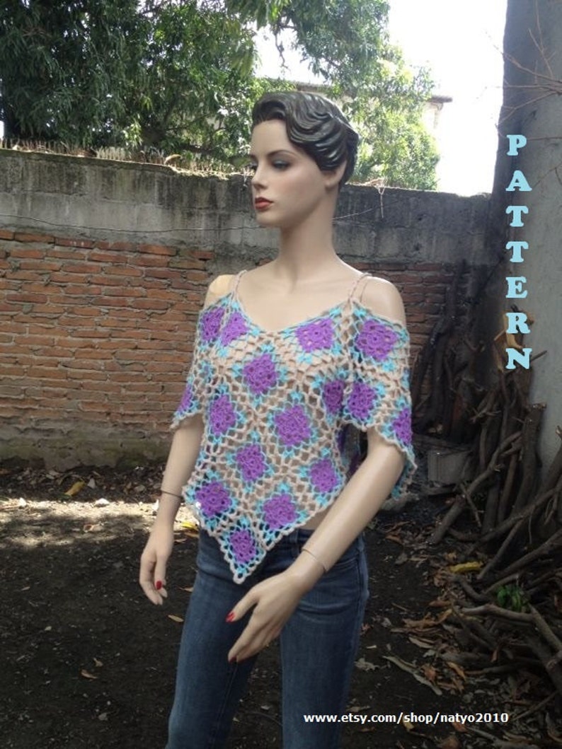 Pode incluir: Um top de croch&ecirc; com um padr&atilde;o roxo, azul e bege. O top tem um decote quadrado e uma forma triangular. O top &eacute; usado por um manequim com jeans azul.