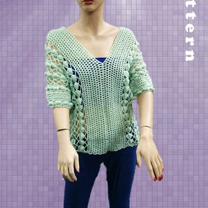 Peut inclure: Un haut en crochet vert clair avec un col en V et un motif ajour&eacute;. Le haut pr&eacute;sente un motif textur&eacute; avec de petites d&eacute;corations rondes. Le haut est pr&eacute;sent&eacute; sur un mannequin.