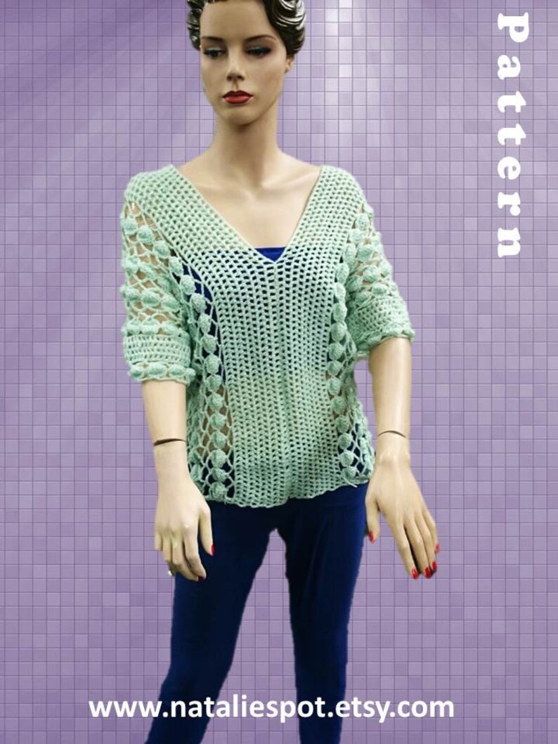 Peut inclure: Un haut en crochet vert clair avec un col en V et un motif ajour&eacute;. Le haut pr&eacute;sente un motif textur&eacute; avec de petites d&eacute;corations rondes. Le haut est pr&eacute;sent&eacute; sur un mannequin.