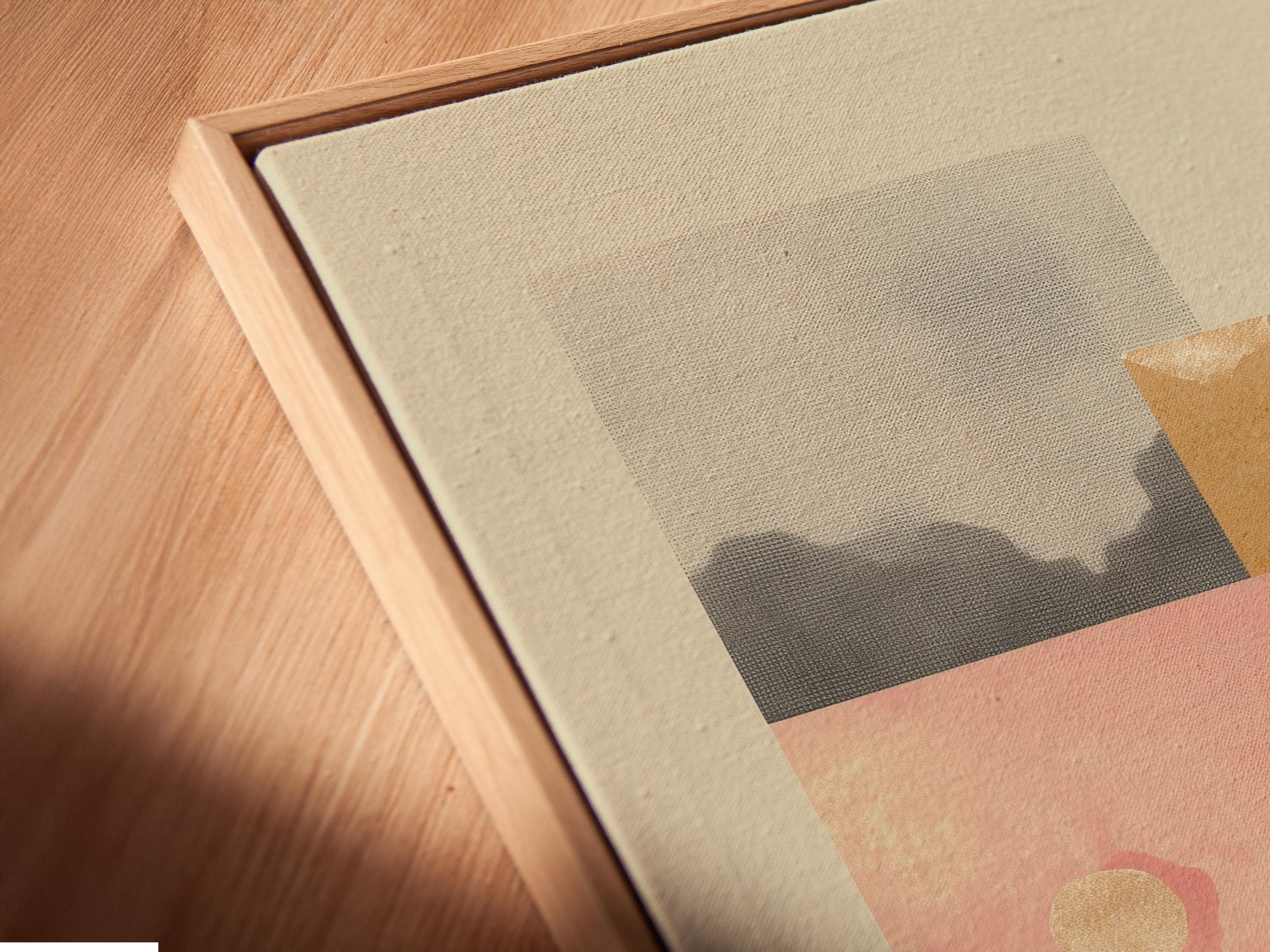 Portrait framed artwork mockup showing a small house and tree silhouettes on beige and pink layered background