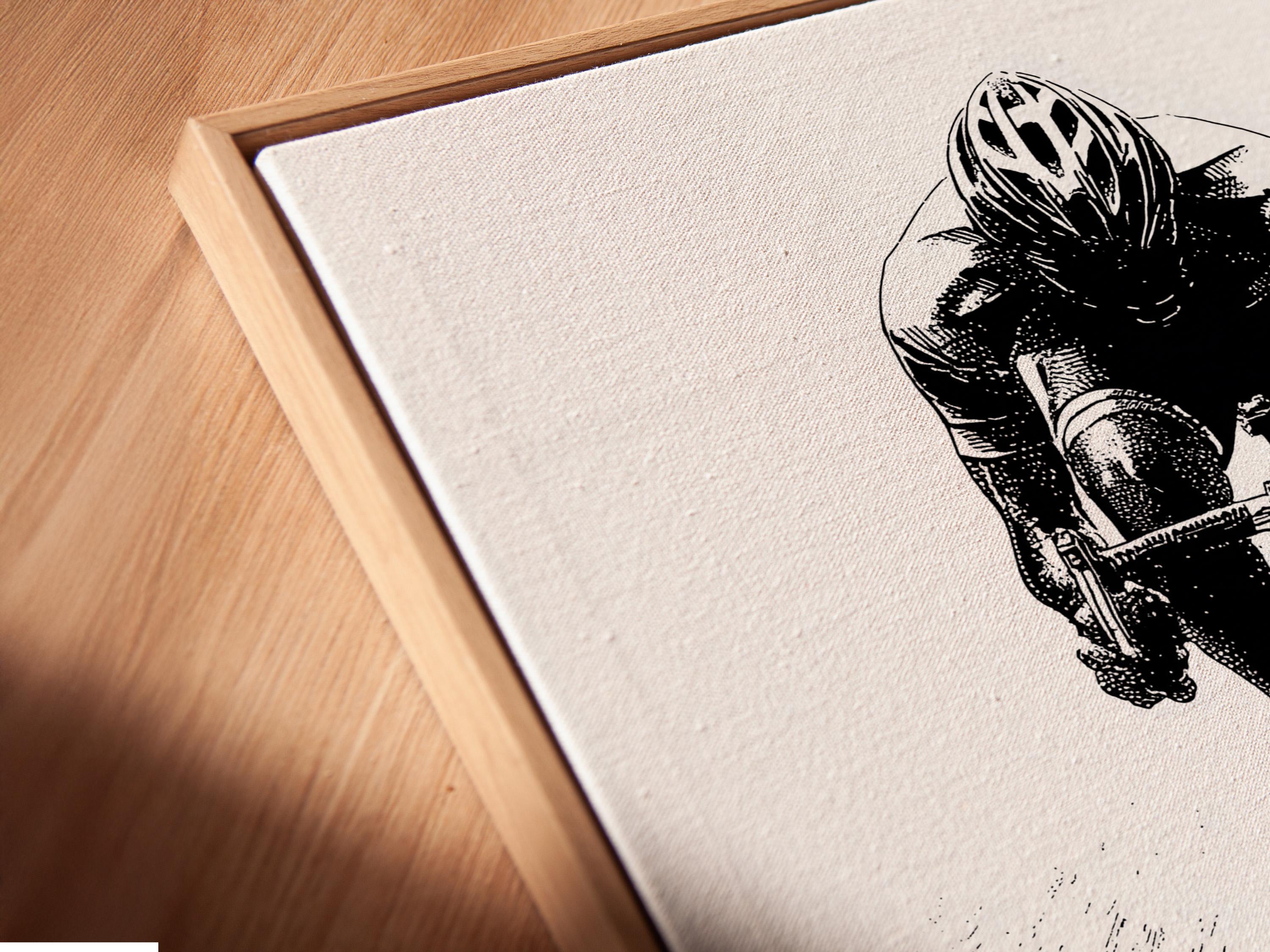 Room mockup showing a framed monochrome cyclist illustration on a light wall