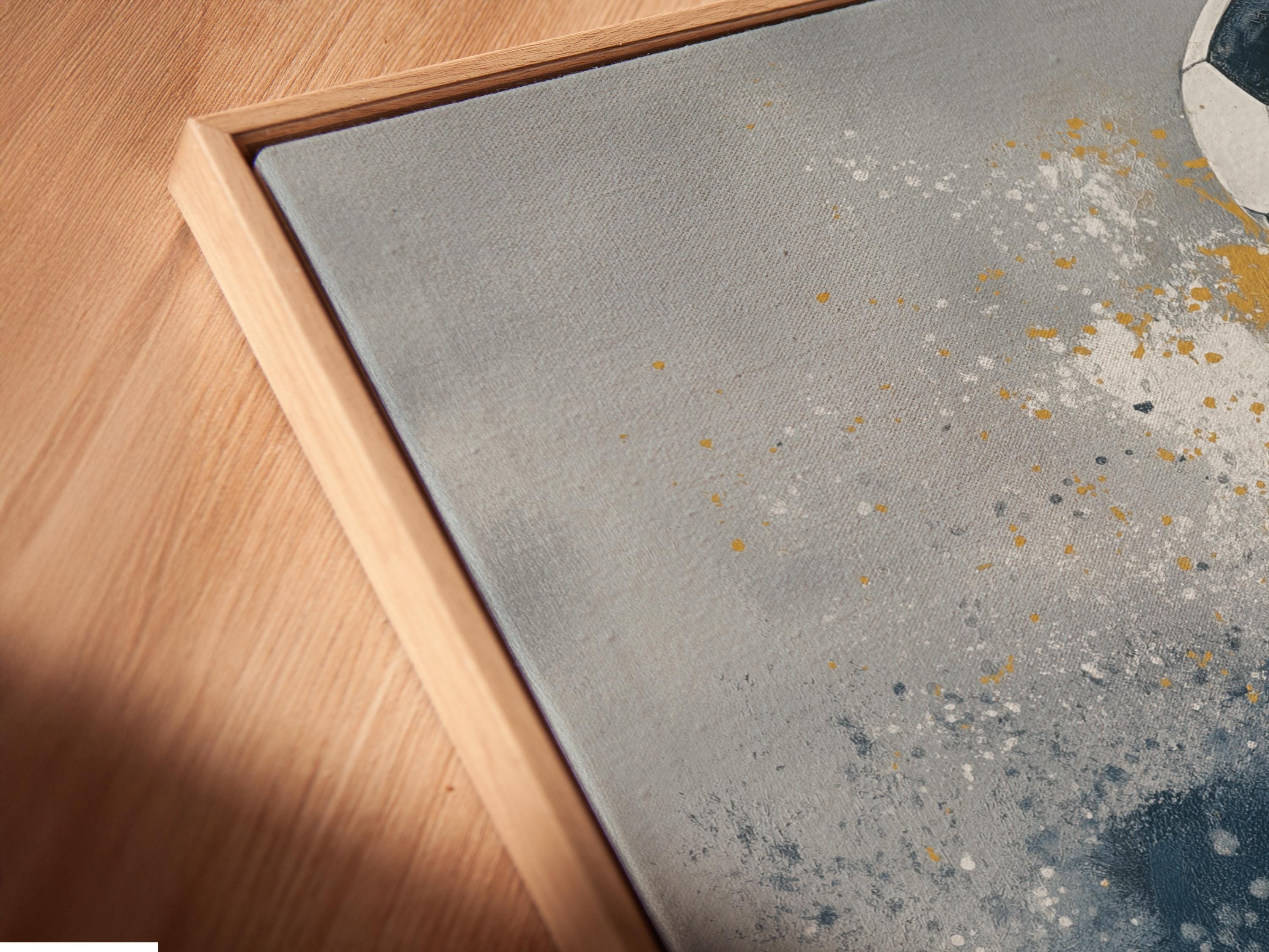 A stylised soccer ball sits on a textured, grey-blue background with scattered white speckles and warm gold paint-like splashes detail view