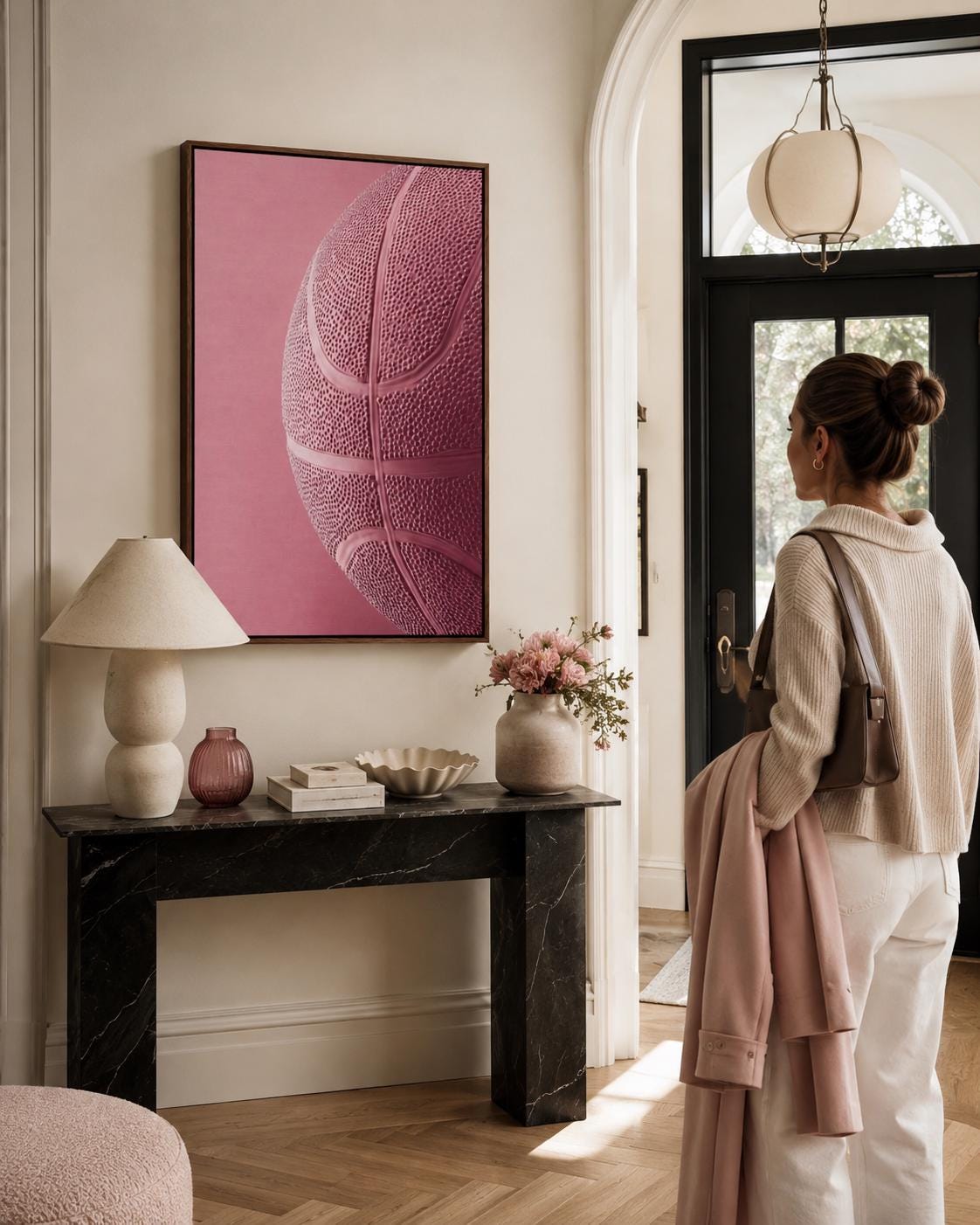 Woman sitting on a sofa beside a framed bubblegum pink basketball artwork