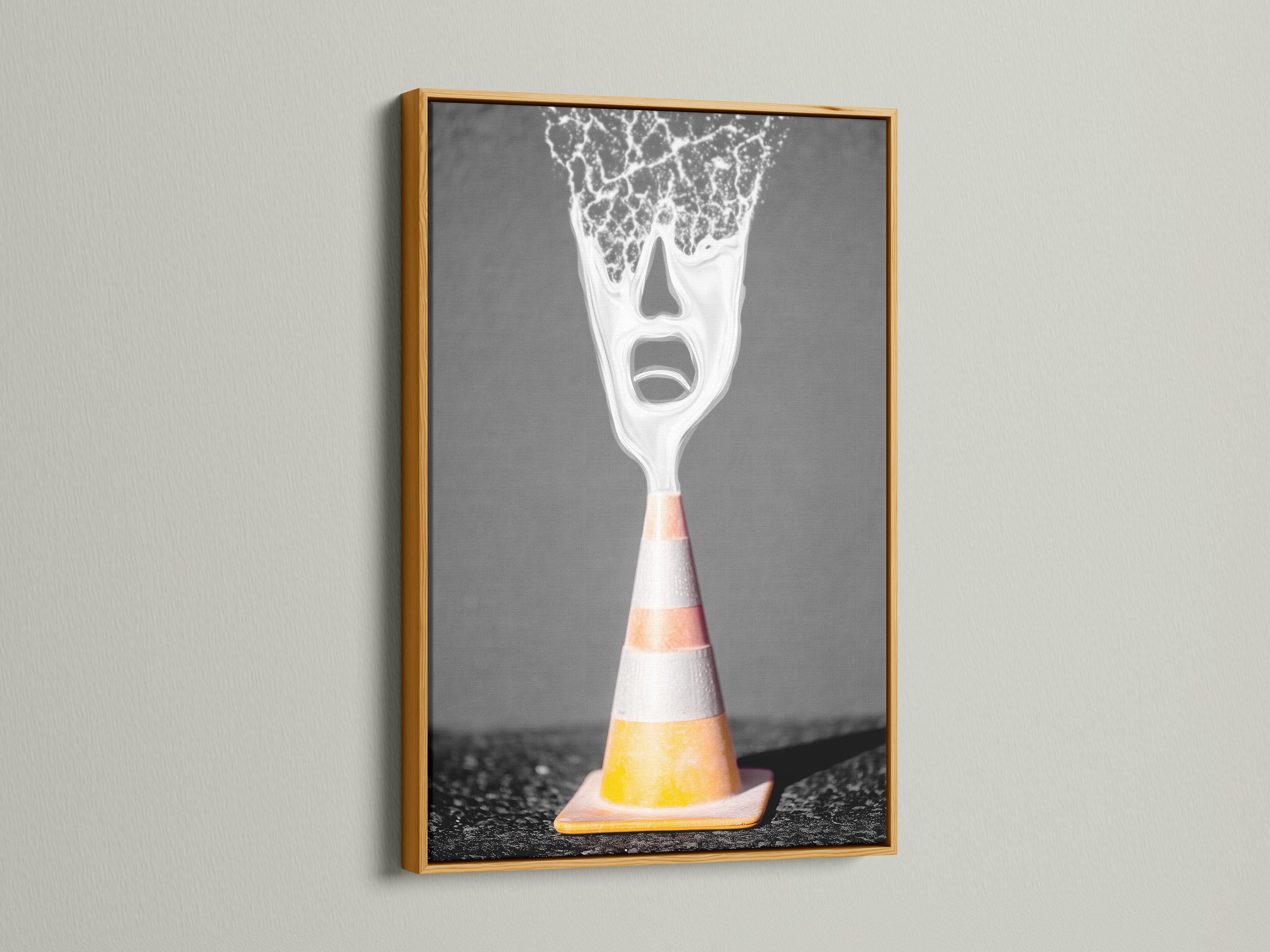 A surreal traffic cone stands on dark ground, its top appearing as a screaming white face with high-contrast, graphic detailing detail view