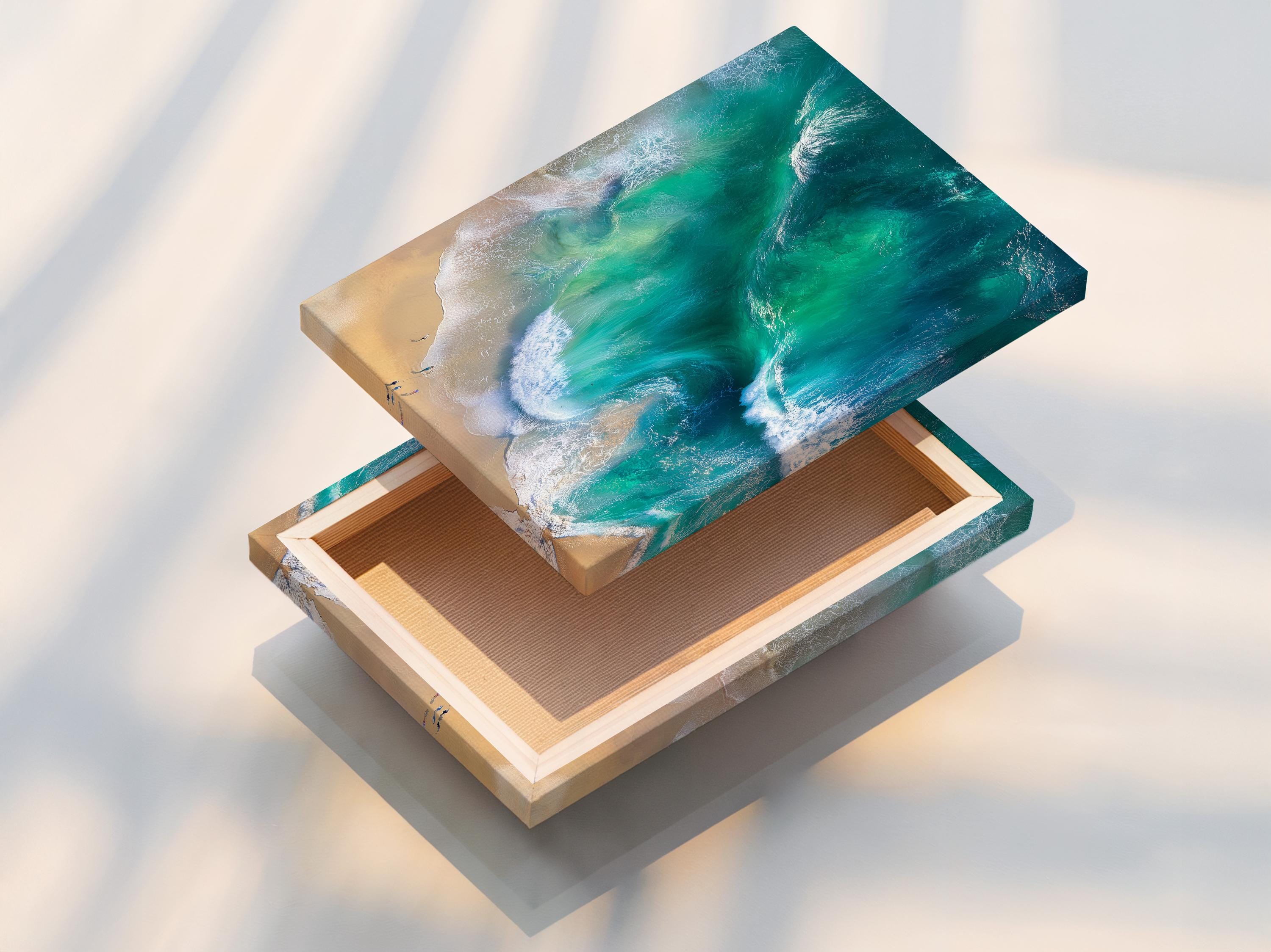 Aerial view of turquoise ocean waves with white foam meeting a sandy beach detail view