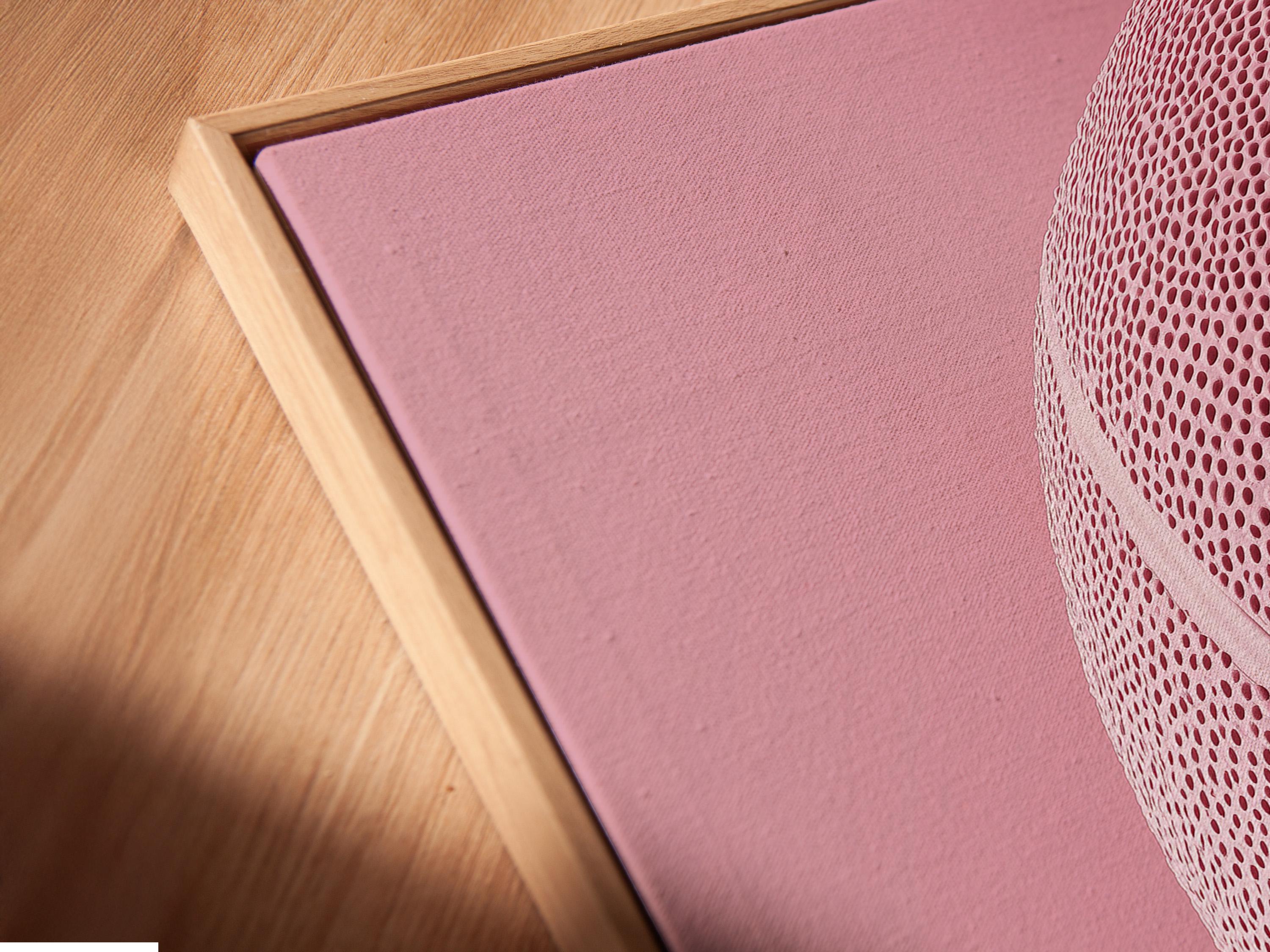 Woman sitting on a sofa beside a framed bubblegum pink basketball artwork