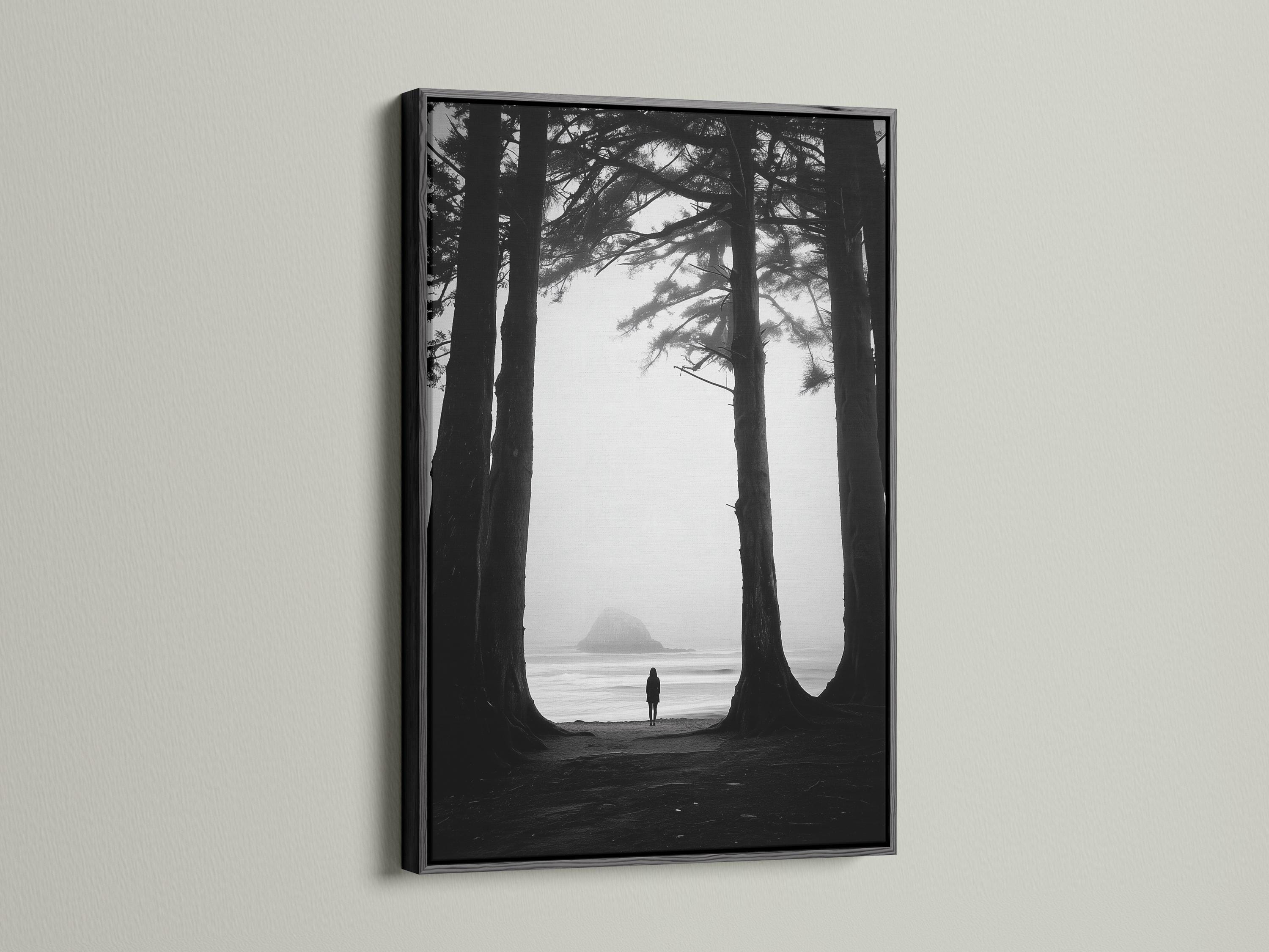 Monochrome seascape with dark tree trunks framing a foggy beach and a small lone figure detail view