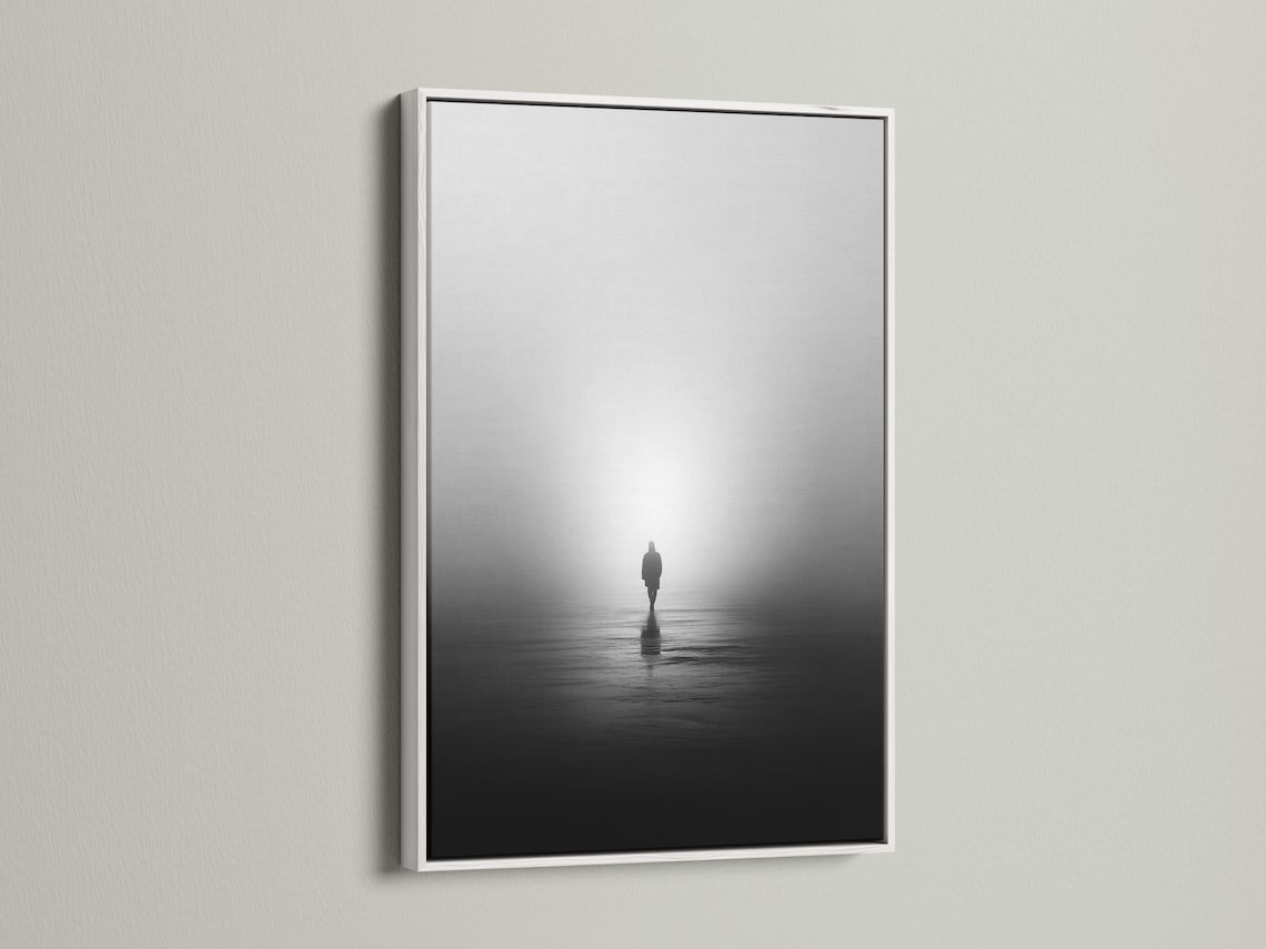 Monochrome misty shore scene with a solitary standing figure and reflection on dark water detail view