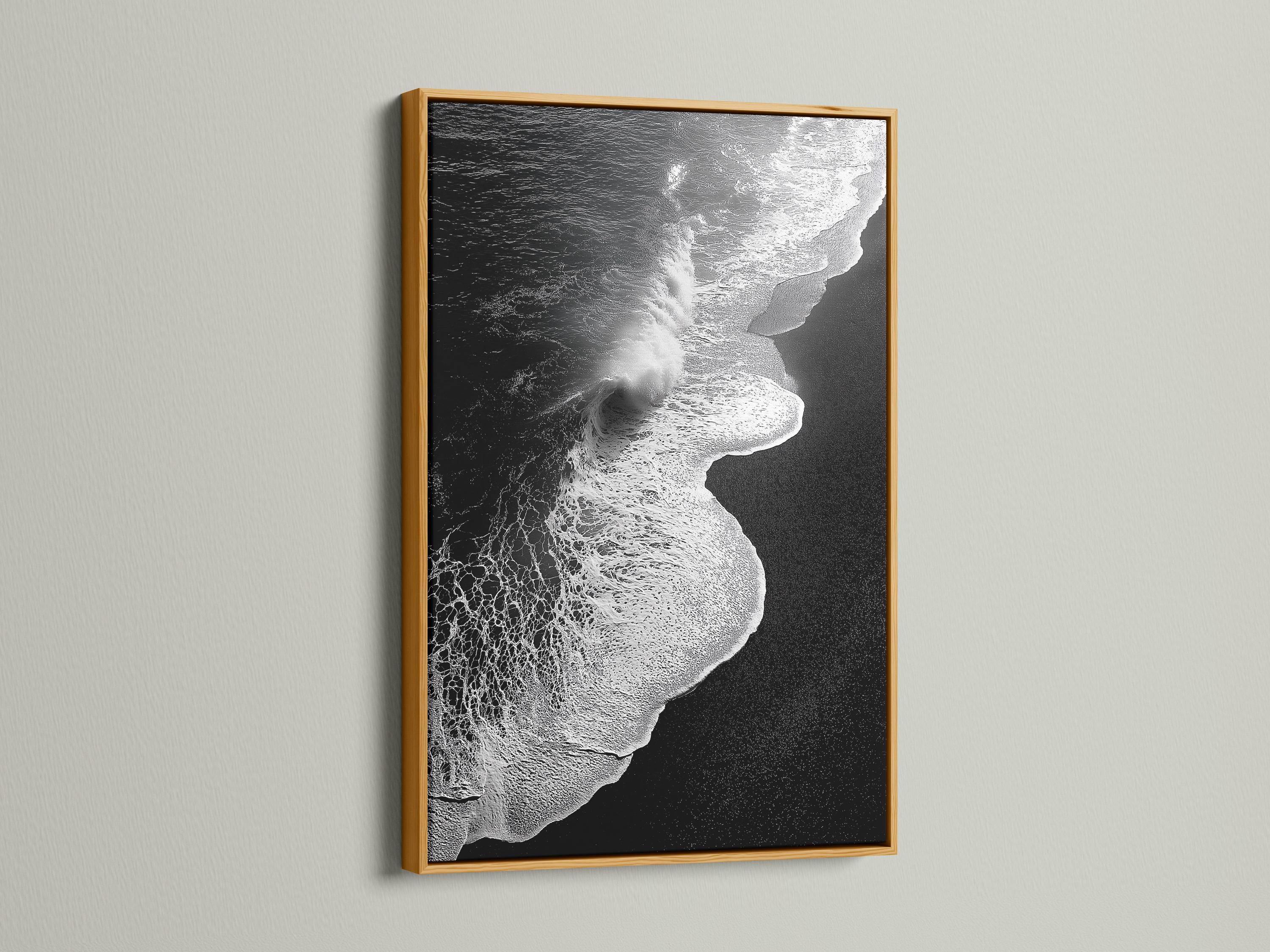 A monochrome seascape shows a foamy wave curling in bright white against deep black water, with a high-contrast, textured finish detail view