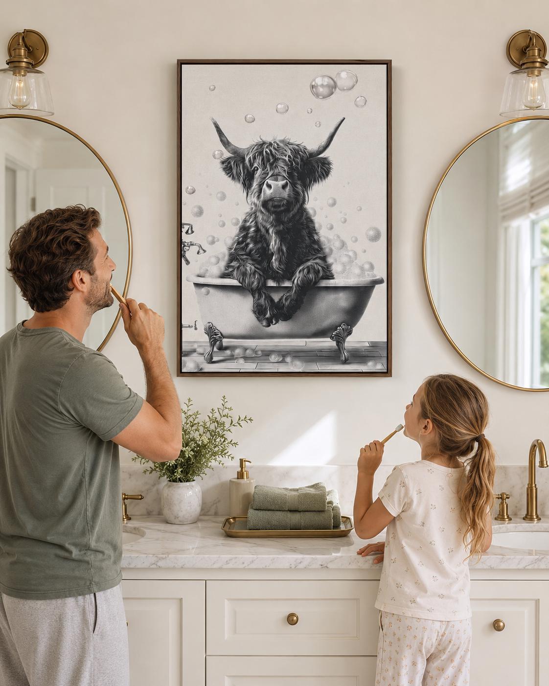 Woman holding a mug standing beside a framed monochrome highland cow bathtub artwork