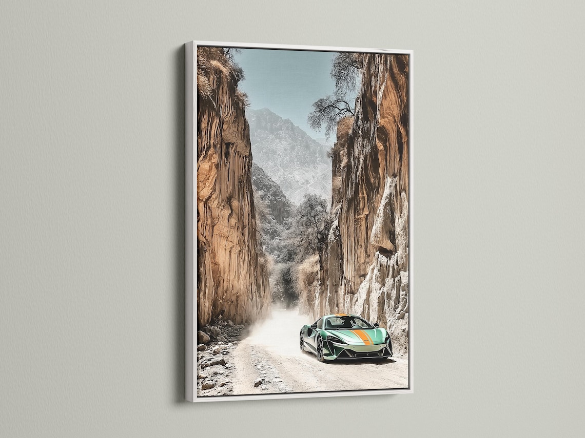 Green sports car on a sandy path in a rocky desert canyon with misty mountains detail view