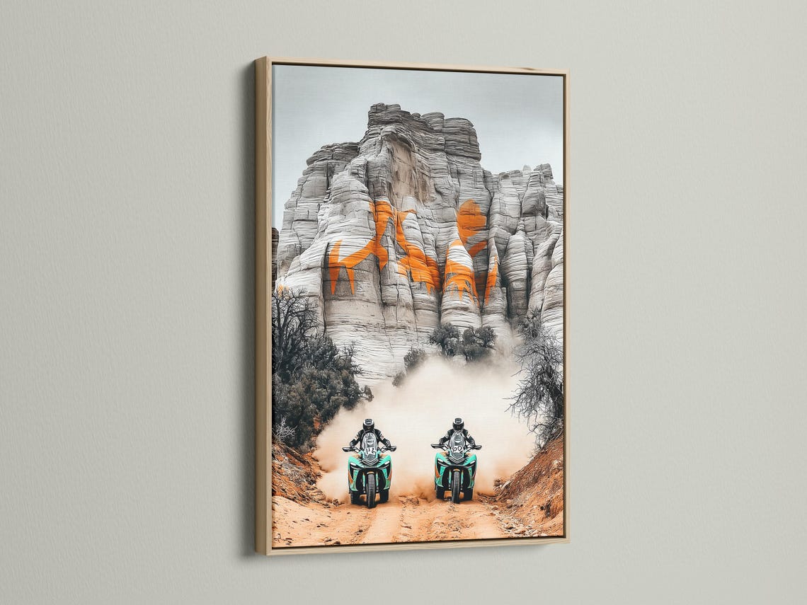 Two off-road motorcycles with turquoise accents racing through desert haze against grey cliffs detail view