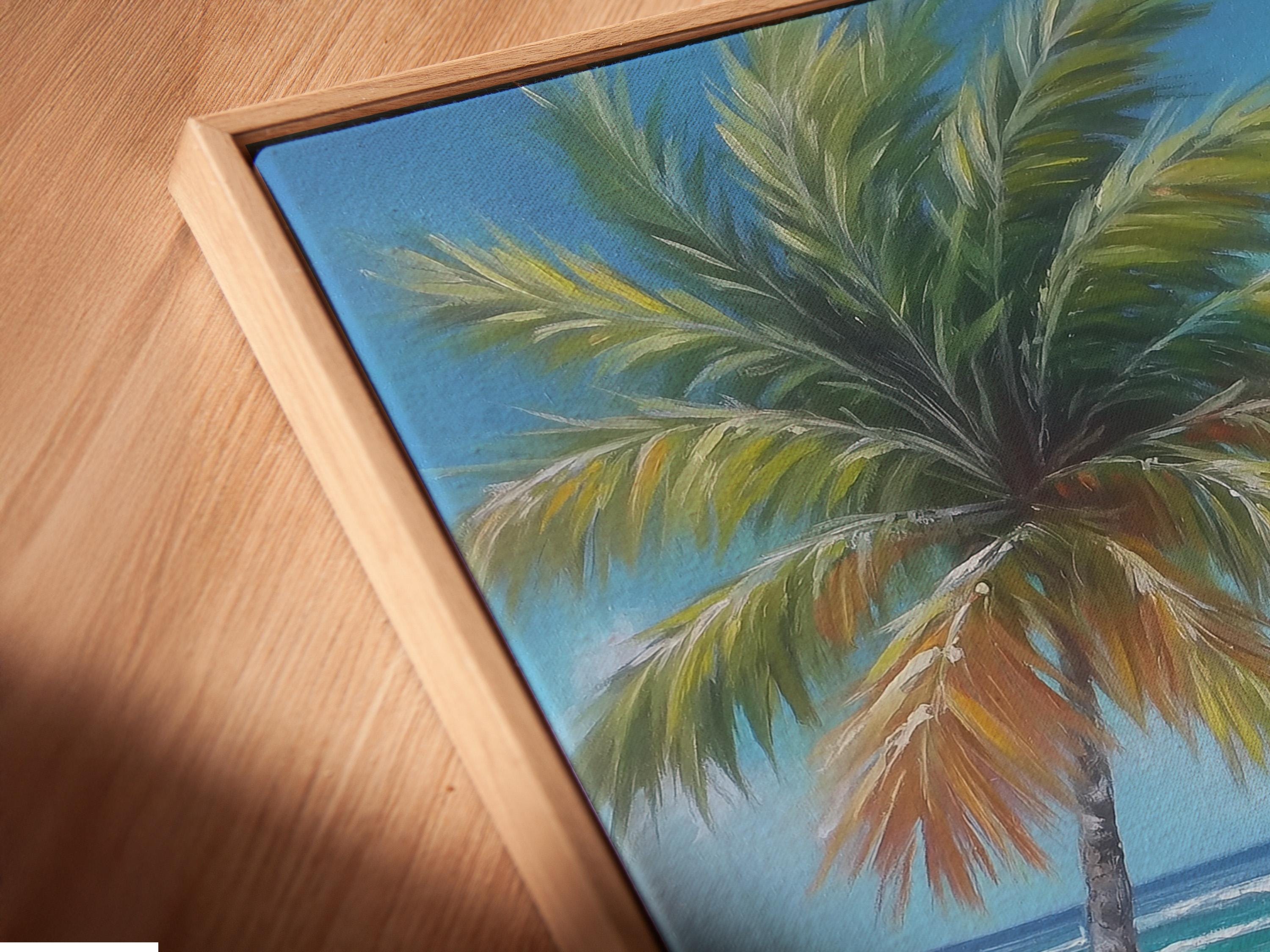 Leaning palm tree over turquoise ocean waves and sandy beach under a bright blue sky detail view