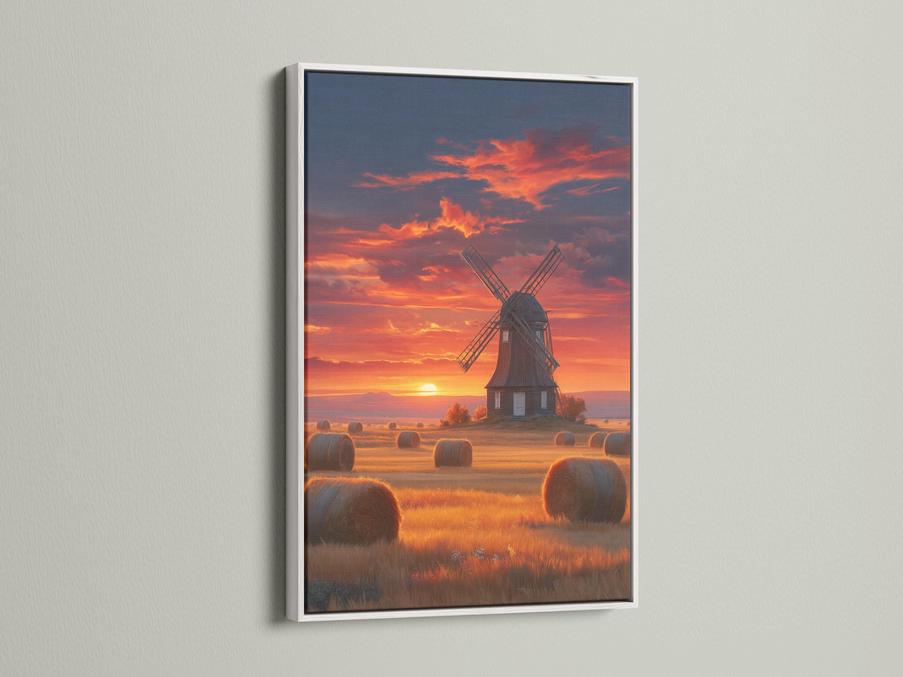 Windmill in a countryside landscape under a glowing sunset sky with hay bales detail view