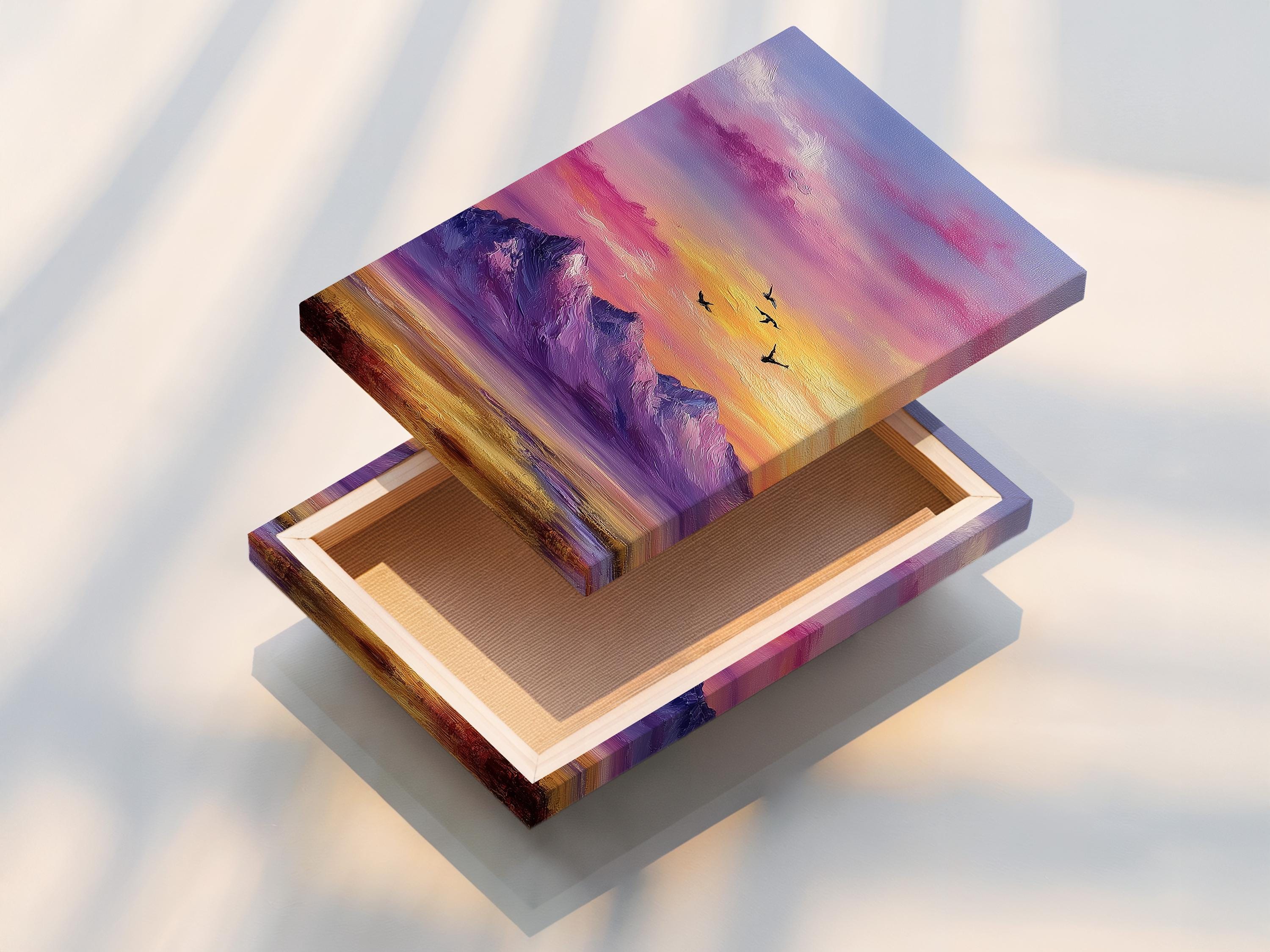 A framed mountain sunset illustration with purple, pink and gold skies and small black birds detail view