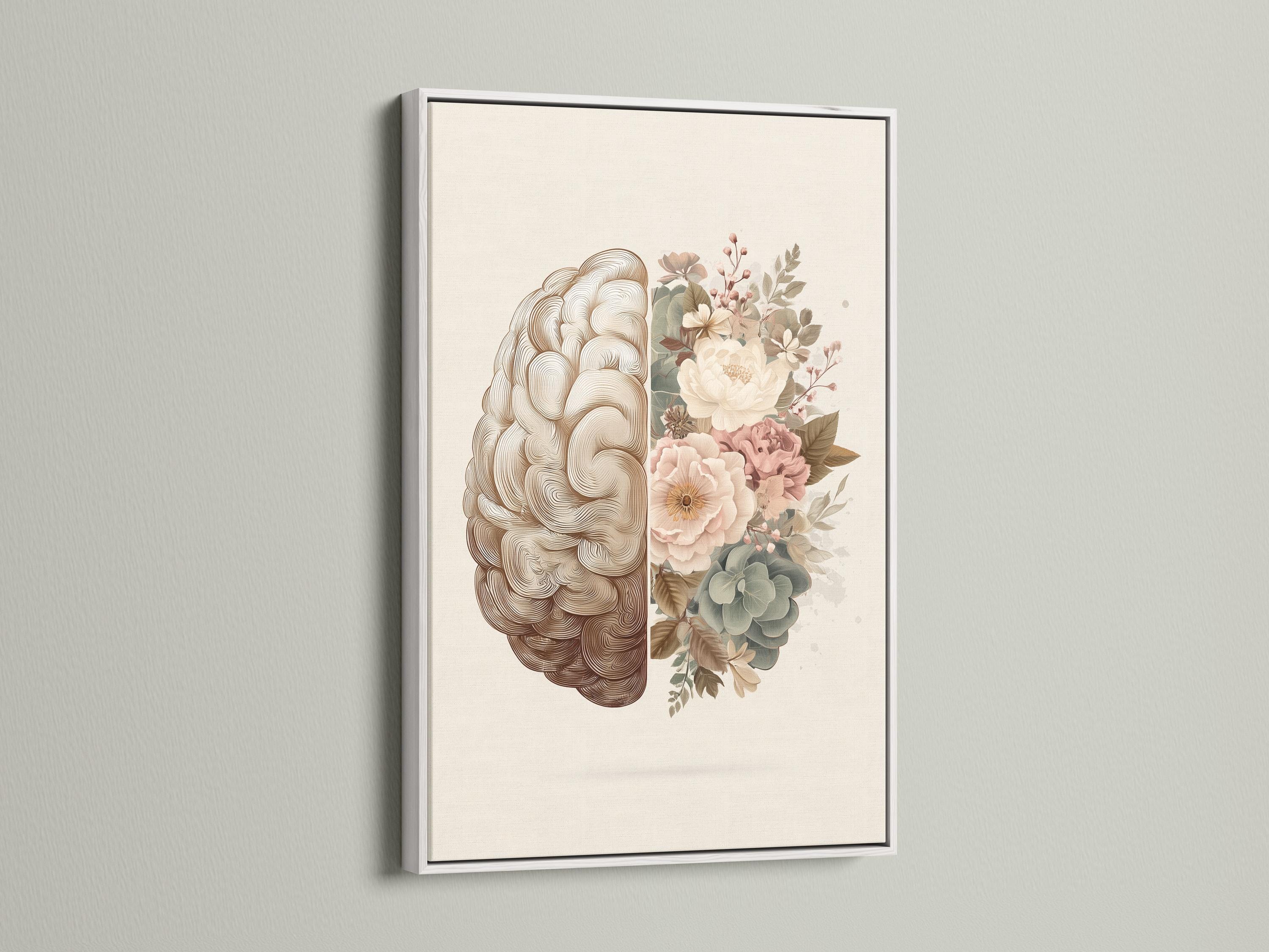 Person reading beside a framed split brain and floral artwork on a floor in a softly lit room