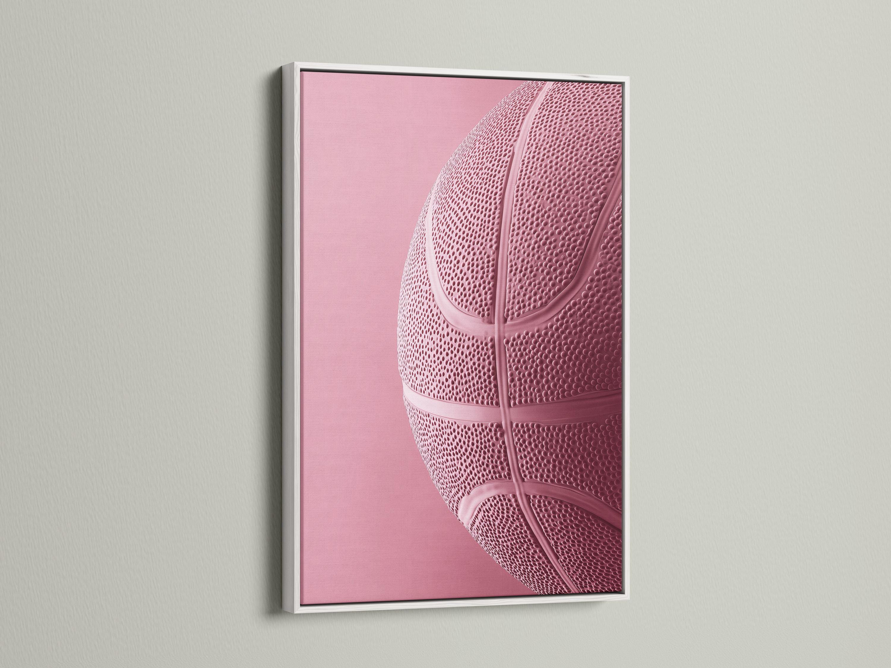 Woman sitting on a sofa beside a framed bubblegum pink basketball artwork