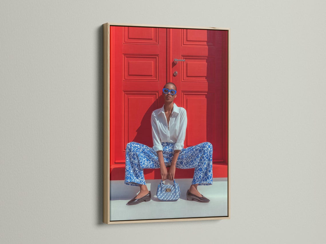 Seated fashion portrait with blue glasses in front of a red door backdrop detail view