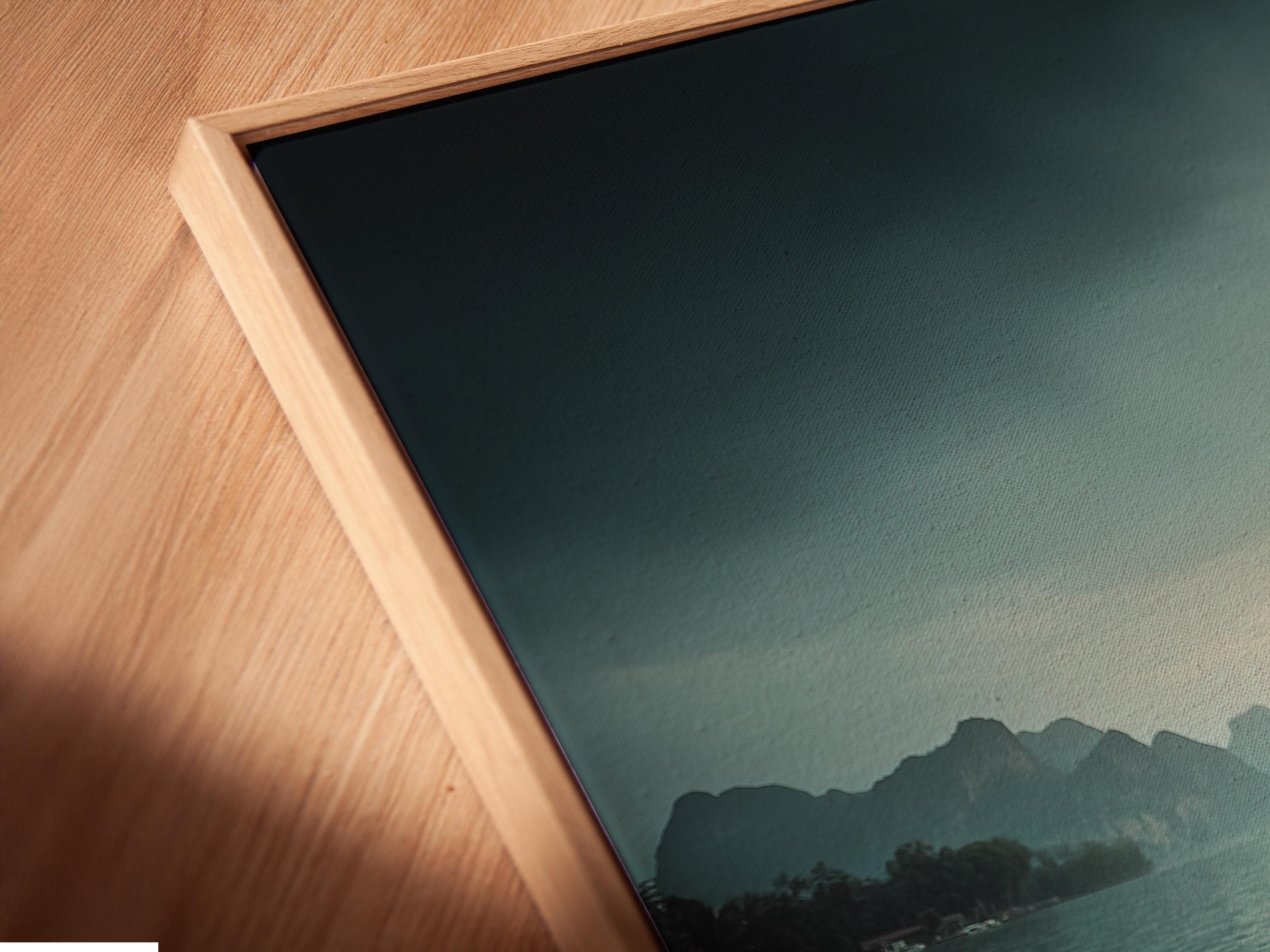 Woman in straw hat sits on a boat facing calm teal water, mountains and a warm sunrise sky detail view