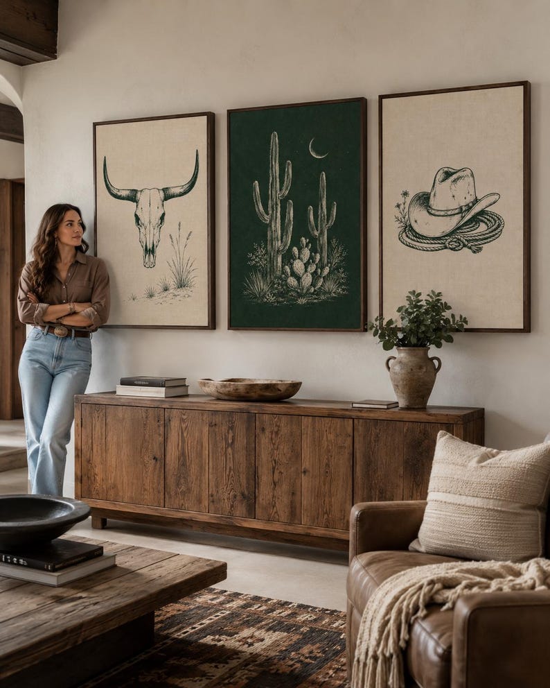 Three framed Western illustrations: cow skull, cacti with a crescent moon, and a cowboy hat with rope