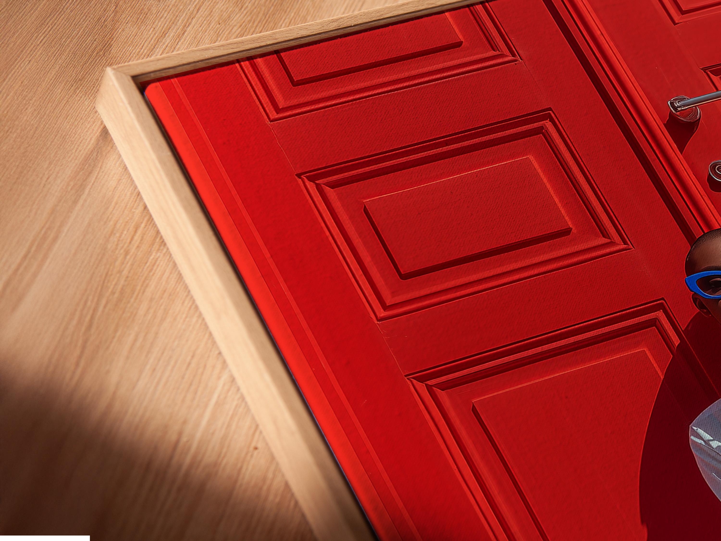 Seated fashion portrait with blue glasses in front of a red door backdrop detail view