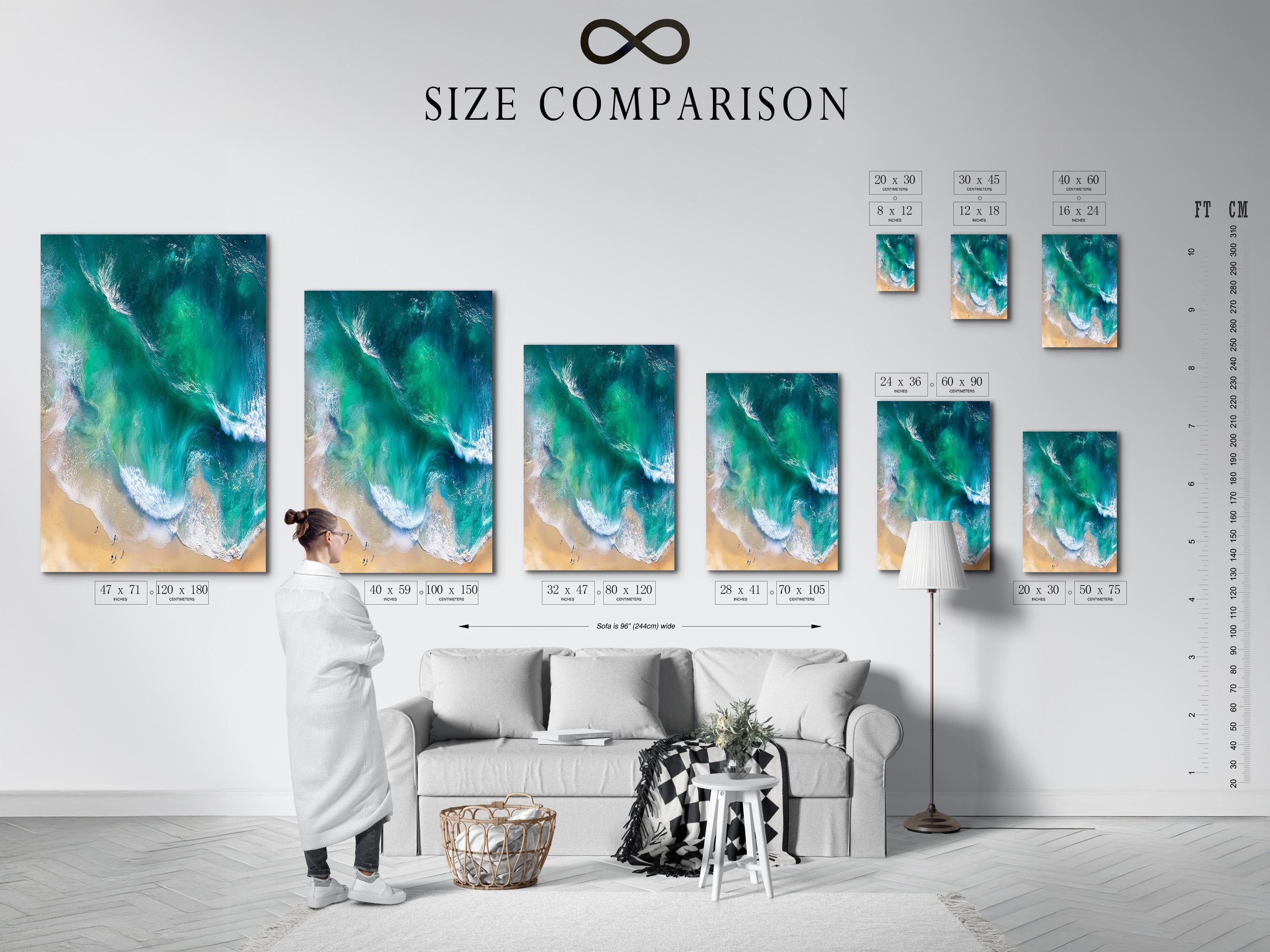 Aerial view of turquoise ocean waves with white foam meeting a sandy beach detail view