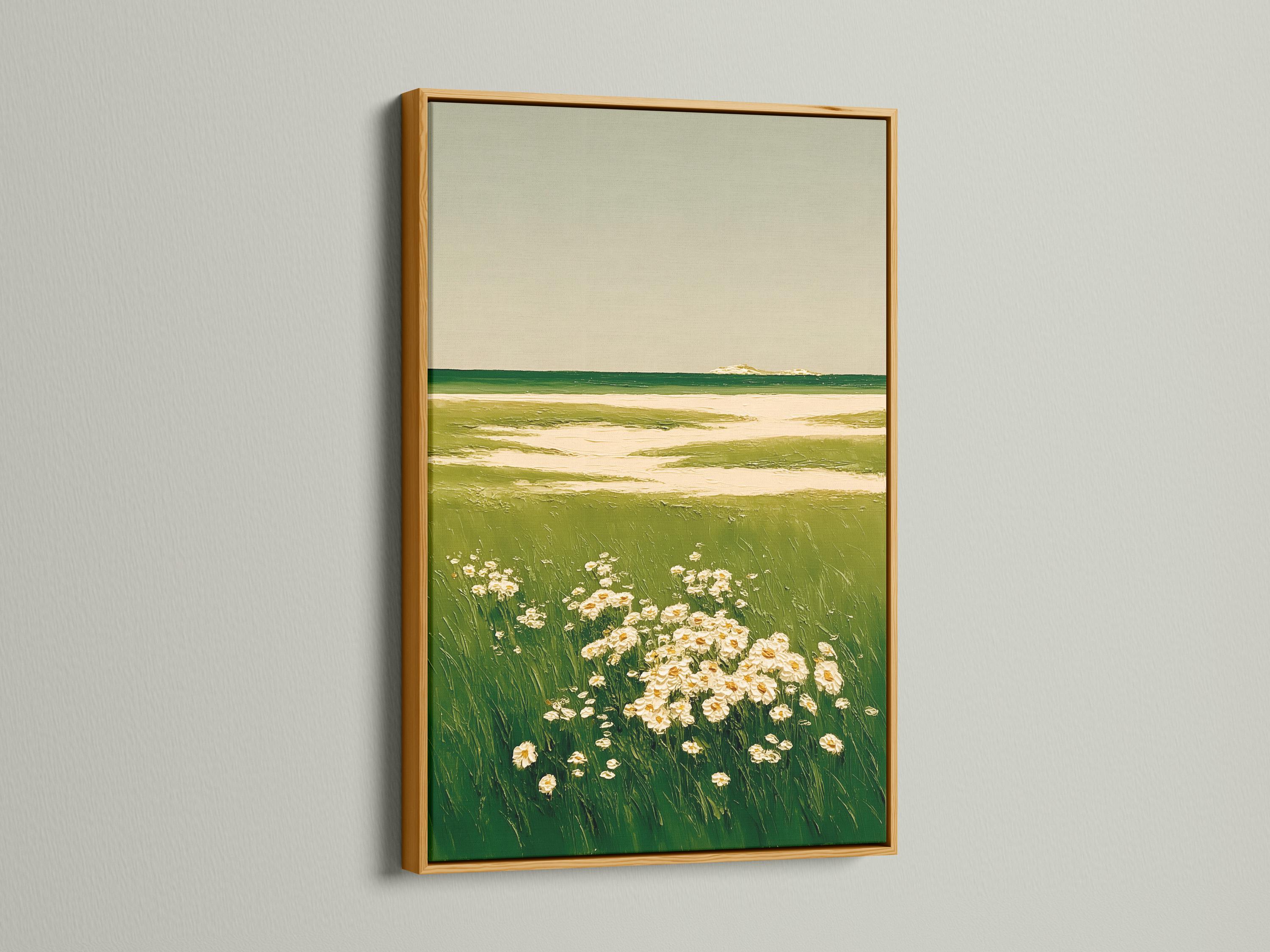 A framed landscape artwork on a light background wall showing green meadow grasses and cream flowers