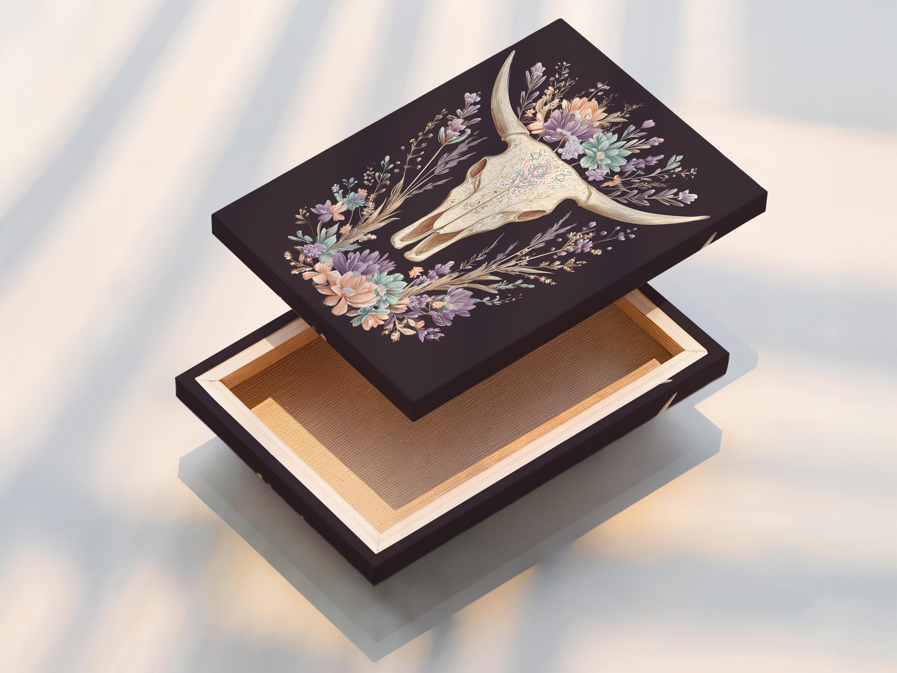 Bull skull illustration surrounded by a wreath of pastel wildflowers on a dark mauve background detail view