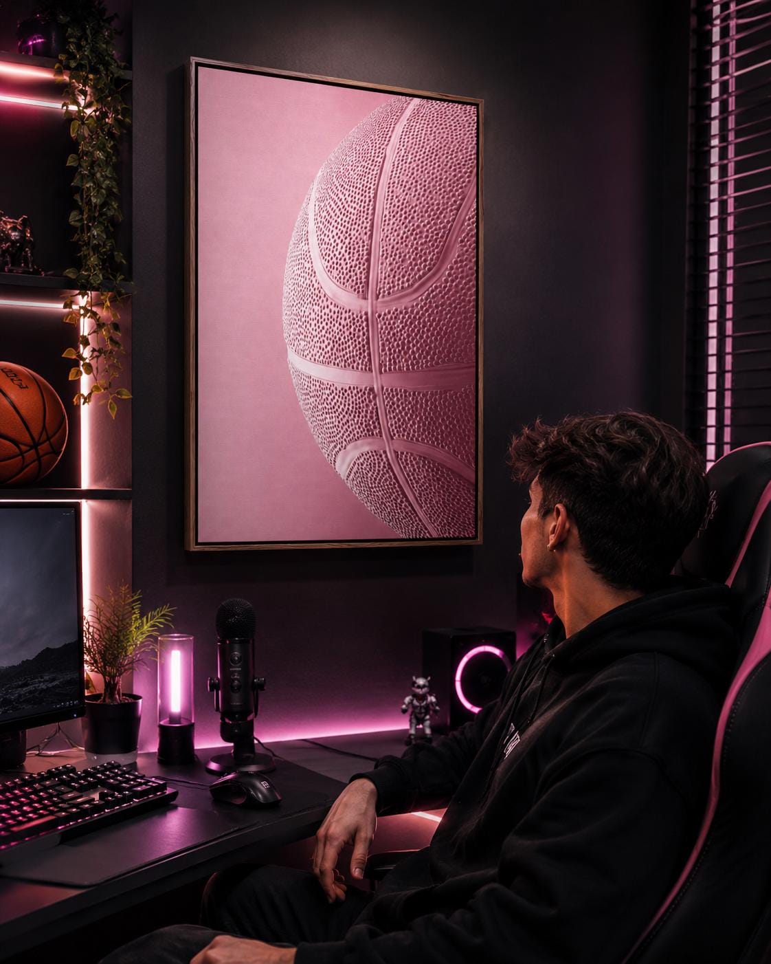 Woman sitting on a sofa beside a framed bubblegum pink basketball artwork