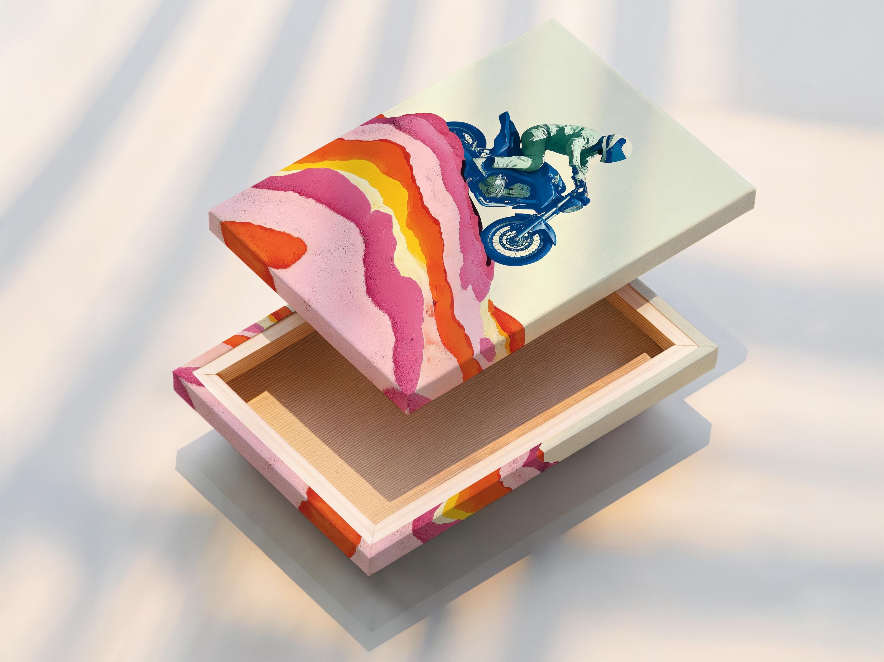 Framed wall mockup showing a stylised blue motorcycle rider over pink and orange mountain ridges