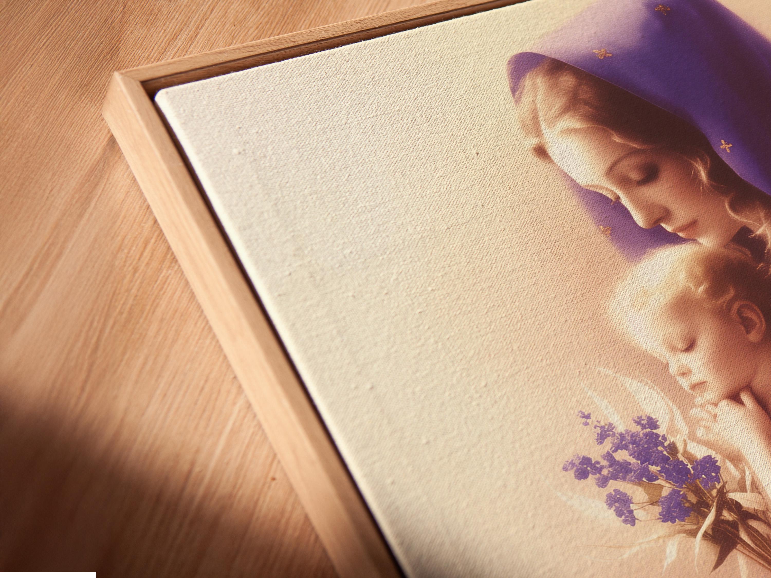 A softly lit Madonna figure in a purple veil holds a smiling baby, with a small bouquet of lilac flowers and delicate gold star-like marks detail view