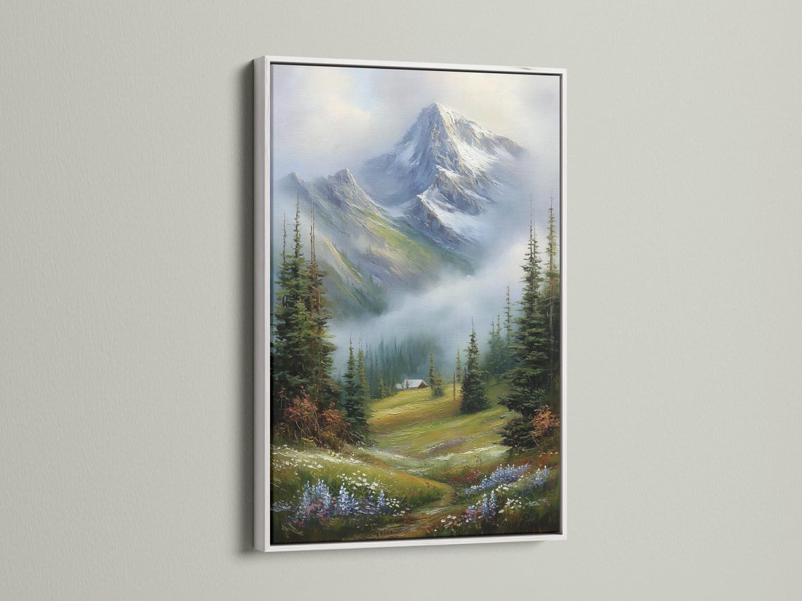 Room mockup showing a framed snowy mountain landscape painting with evergreen trees and a cabin