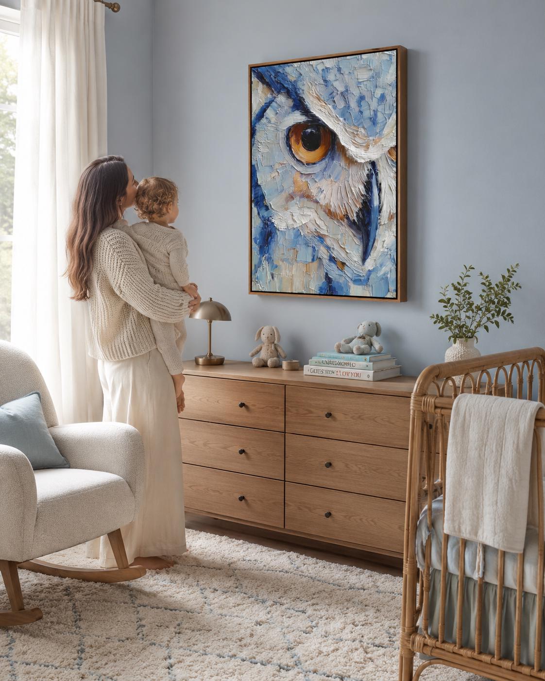 Room scene with a framed blue owl painting above a desk where a person writes in a book