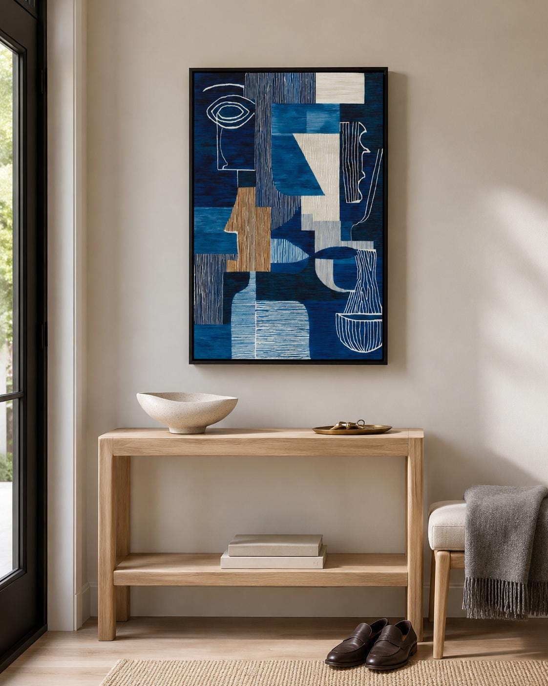 Woman holding a cup in a cafe-like space with a framed blue abstract face artwork on the wall