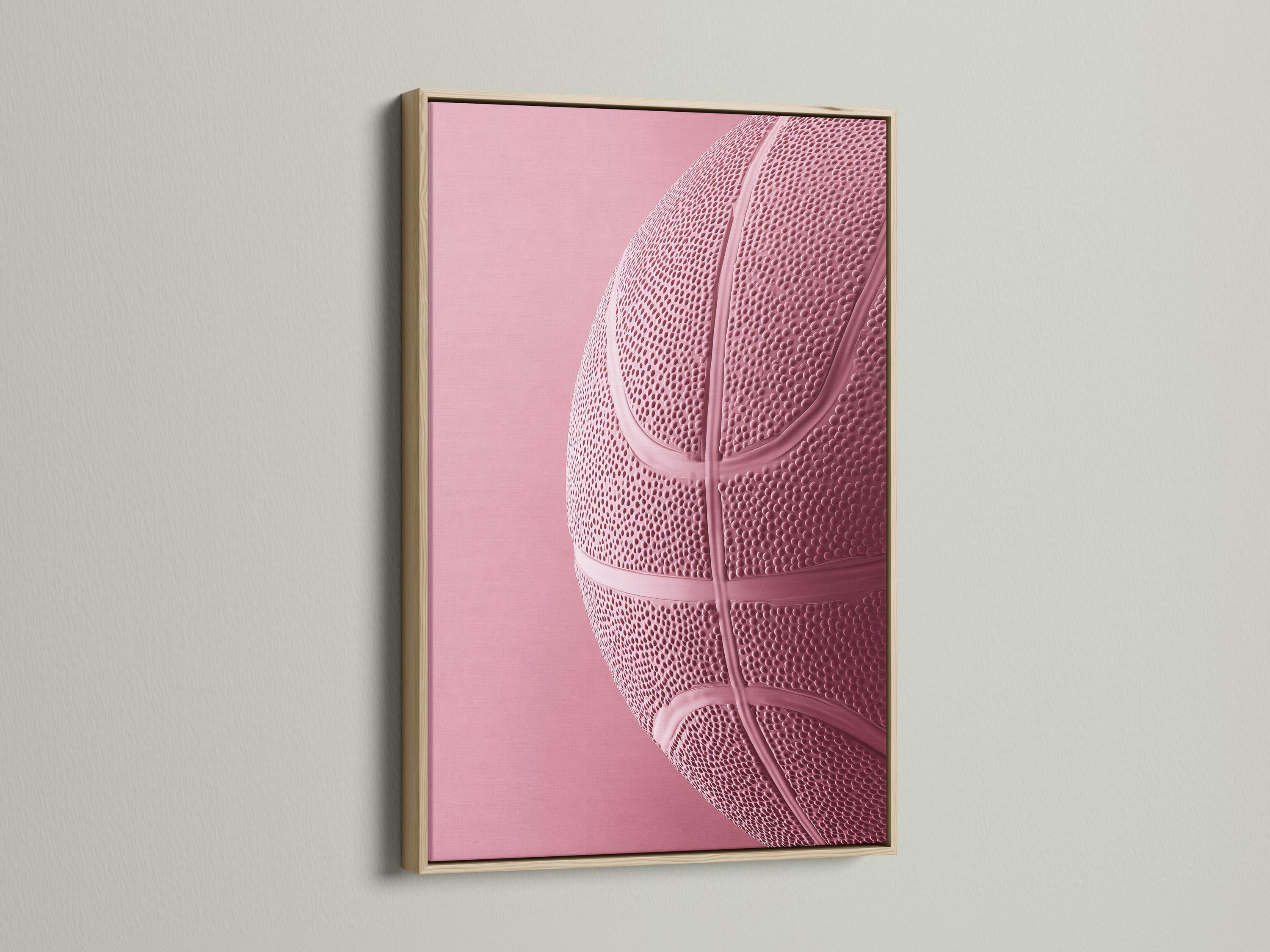Woman sitting on a sofa beside a framed bubblegum pink basketball artwork