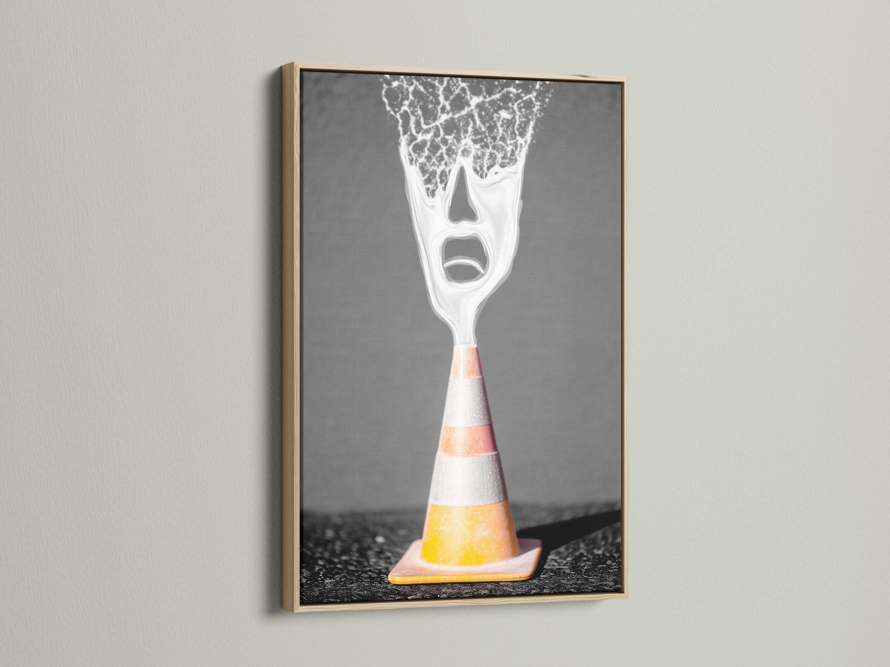 A surreal traffic cone stands on dark ground, its top appearing as a screaming white face with high-contrast, graphic detailing detail view
