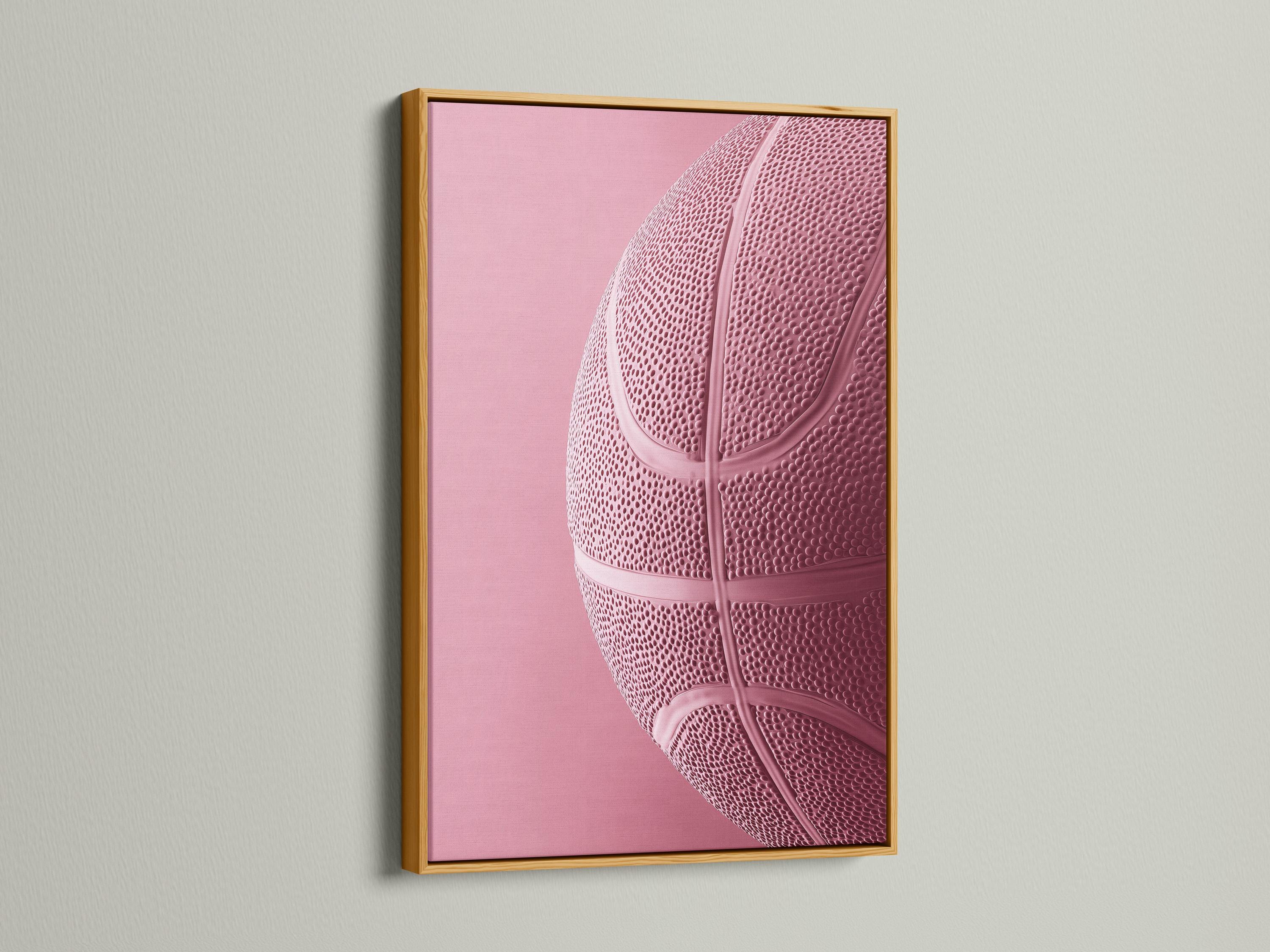 Woman sitting on a sofa beside a framed bubblegum pink basketball artwork